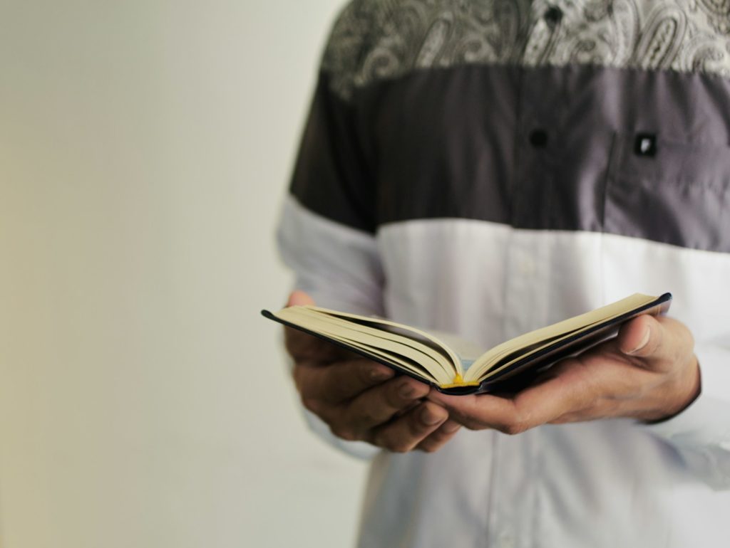 person in black and gray button up shirt reading book